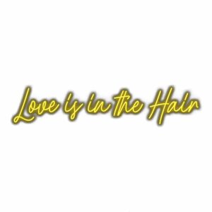 Neon sign text "Love is in the Hair